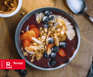 Auf dem Bild ist eine Acai Bowl zu sehen, welche mit diversen Beeren und Früchten garniert ist.