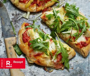Zu sehen ist ein Bild von einer Pizza belegt mit Rucola.