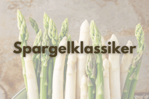 Auf dem Bild sieht man grünen und weißen Spargel vor einer Steinplatte.