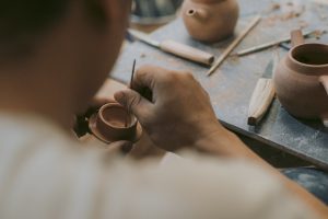 Person bemalt handgefertigte Keramikschale mit feinem Pinsel.