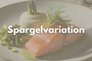 Man sieht ein Stück Lachsforellenfilet, Spargelmousse und Spargelsalat auf einem Teller drapiert.